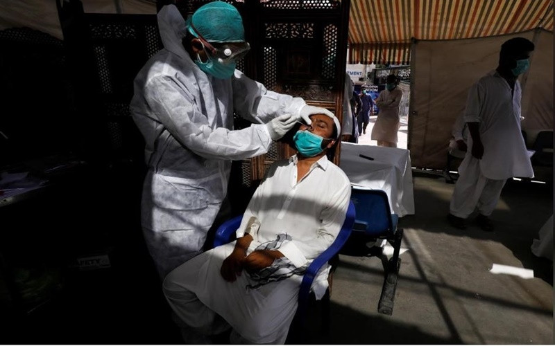 Chuyên gia y tế tỉnh Sindh của Pakistan cho biết có 3 người ở thành phố cảng Karachi cho kết quả dương tính với biến thể mới của virus SARS-CoV-2. Họ đều là những người mới về từ Anh. Ảnh: Nhân viên y tế lấy mẫu xét nghiệm COVID-19 tại Karachi, Pakistan, ngày 27/6. Ảnh: Reuters.