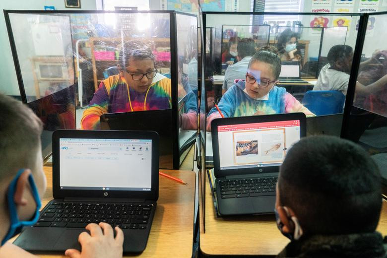 Ellyah Gonzalez và Lazae Palacios, đều 10 tuổi, ngồi học trong lớp học có vách ngăn bằng nhựa phòng COVID-19 tại trường Tiểu học Louise, bang Texas, ngày 20/11.