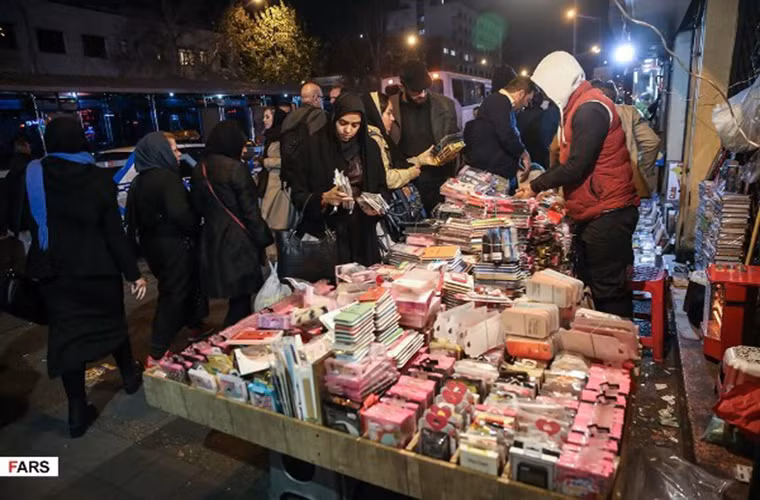 Người dân mua đồ tại một sạp hàng ngoài đường phố Tehran. Ảnh: FNA.