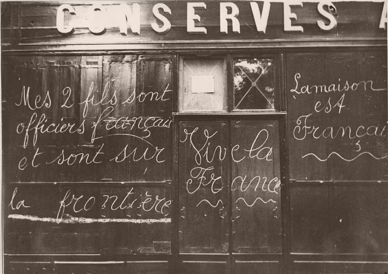 Dòng chữ có nội dung thông báo hai người con trai của chủ cửa hàng này đã đi lính năm 1914.