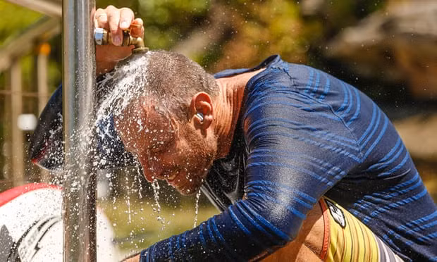 Brenton Fisher cúi đầu dưới vòi nước công cộng tại khu vực bãi biển Tamarama ở Sydney hôm 7/1. Ảnh: AAP.