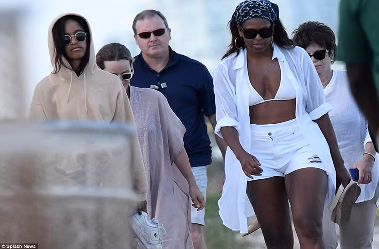 Phu nhân của cựu Tổng thống Obama xách giày và đi chân trần trên cát ở bãi biển bang Florida.