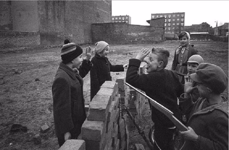 Các em nhỏ chơi đùa cạnh bức tường đang xây dở ở Berlin năm 1962. Ảnh: Telegraph.