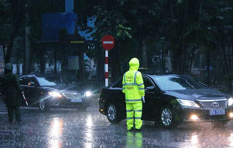 Dưới cơn mưa, lực lượng chức năng làm nhiệm vụ trước cửa Nhà tang lễ Quốc gia vẫn chốt trực để đảm bảo an ninh trật tự trong lễ Quốc tang.