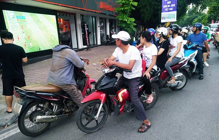 Các cổ động viên đủ mọi lứa tuổi cả nam và nữ cũng nán lại bên đường để cổ vũ cho đội tuyển Việt Nam.