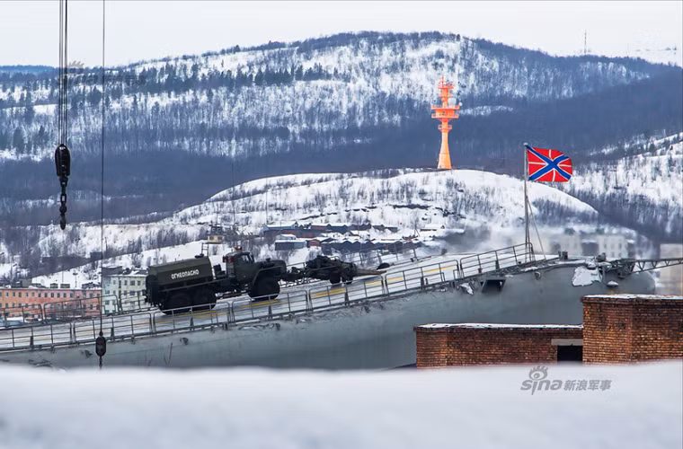 Phương tiện đặc chủng đang phun hơi nóng làm tan băng bám trên mặt boong tàu sân bay.