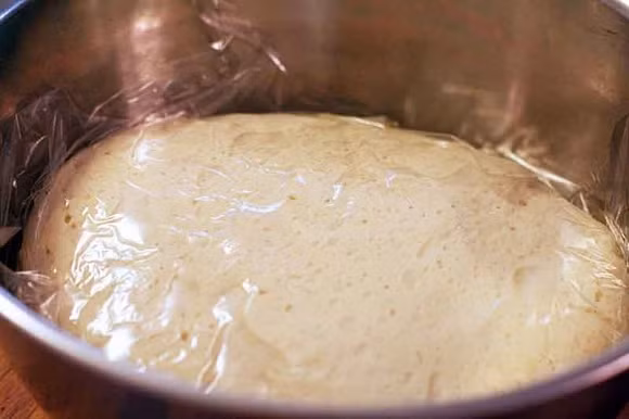 Sau đó cho phần bột mì đã nhồi vào âu nhỏ và bịt kín lại để bột nở phồng lên trong 5 phút. Ảnh: Giainhan.