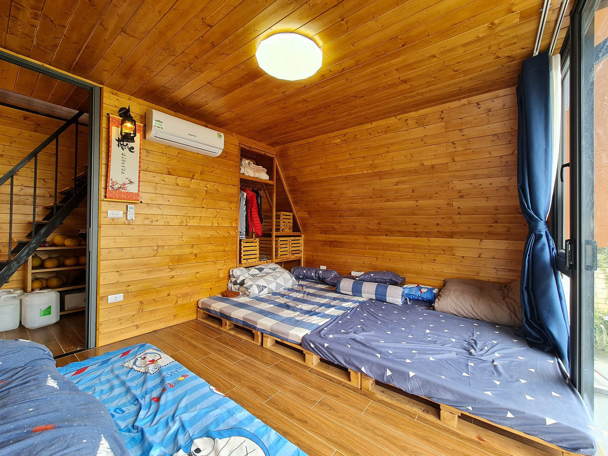 Nội thất sử dụng chất liệu chủ đạo là gỗ, tông màu nâu, tạo cảm giác mát mẻ vào mùa hè và ấm áp vào mùa đông. Ảnh: Phan Hồng Sơn Đối với không gian nghỉ ngơi như phòng ngủ, phòng ăn và phòng khách, anh Sơn ưu tiên sử dụng hệ cửa kính cỡ lớn, vừa có công dụng lấy sáng và thông gió, tạo cảm giác thoáng đãng, rộng rãi, vừa xóa nhòa ranh giới với thiên nhiên bên ngoài.