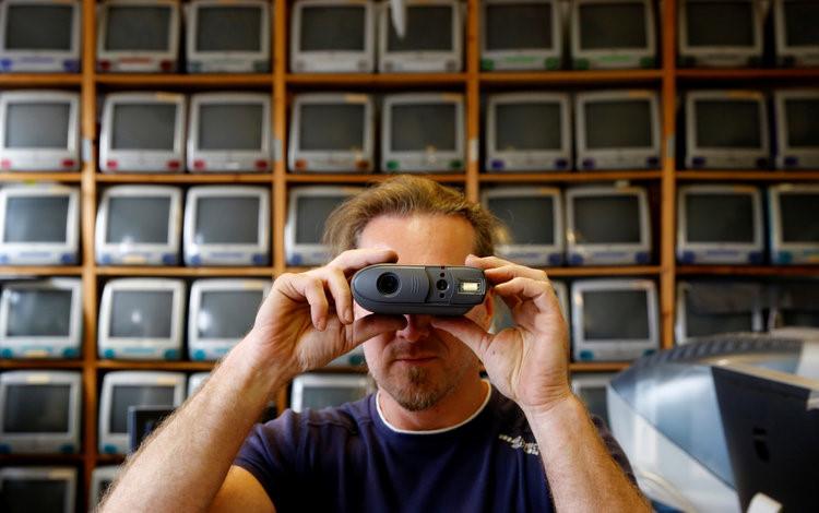 Roland Borsky xin hoặc mua lại những thiết bị mà người dùng không cần đến. "Cũng giống như những người có sở thích sưu tầm xe hơi hay nhiều thứ khác, đây là niềm đam mê của tôi", anh nói. Trong ảnh, Borsky đang cầm chiếc máy ảnh Quicktake ra đời năm 1994.