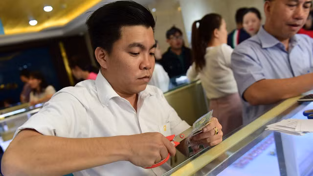 Do khan hiếm vàng miếng SJC loại 5 phân, 1 và 2 chỉ nên nhiều người chuyển qua mua vàng nhẫn. Trong ảnh: nhân viên Công ty SJC cắt vàng nhẫn ép vỉ để bán cho khách hàng. Ảnh: Quang Định.