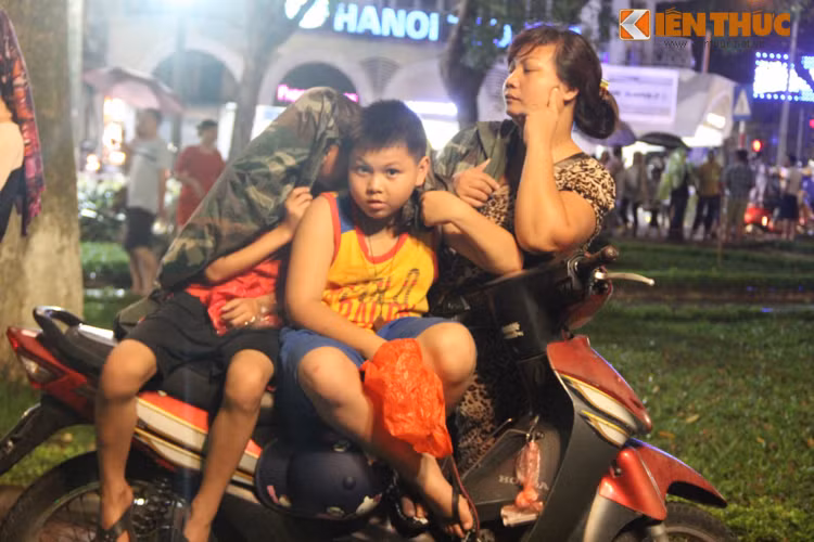 Ngay cả những em bé cũng háo hức đội mưa chờ màn bắn pháo hoa.