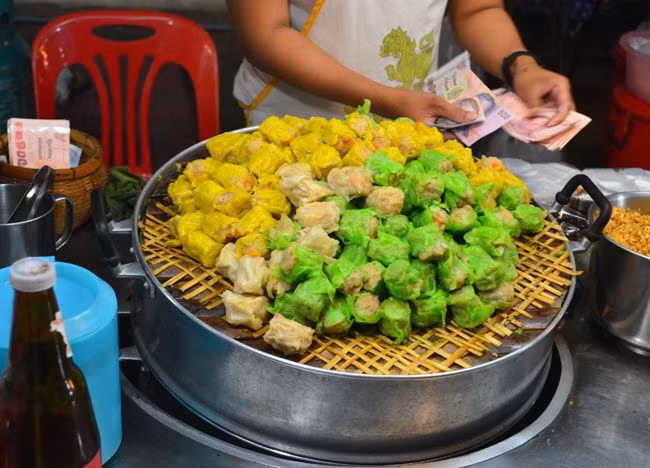 Vẫn là miếng bánh nhân thịt bọc ngoài một lớp bột như dimsum ở Hong Kong nhưng kanom jeeb có màu sắc phong phú hơn, miếng bánh khô hơn và mang vị cay cay, mặn mặn đặc trưng của đồ ăn Thái. Nhân của loại bánh này cũng khá biến tấu. Nó có thể làm từ tôm, nấm shitake hay hạt dẻ nước. Khi thưởng thức, chúng ta dùng chung với nước sốt nóng hoặc nước sốt tỏi chiên.