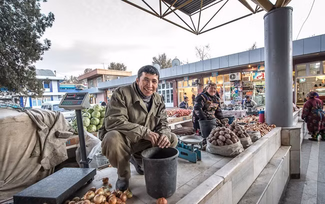 Một số tiểu thương khác thì bày hàng bán ngay ngoài cổng chợ. Đồ đạc đơn giản chỉ bao gồm một chiếc cân và hàng hóa đựng trong bao tải.