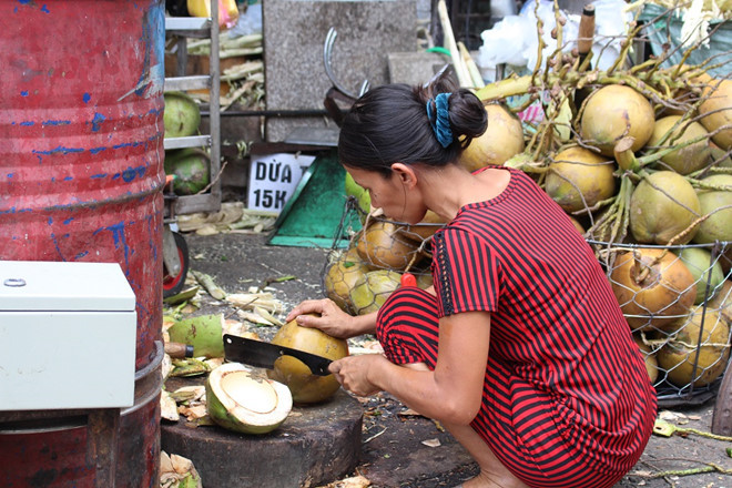Vợ chồng anh Trình phải luôn tay, luôn chân làm việc cả ngày phục vụ nước mía và dừa lạnh cho khách hàng. Ảnh: Phúc Minh.
