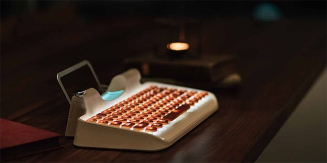 Núm tròn này được sử dụng để nạp giấy vào cơ chế máy đánh chữ, nó cũng là núm âm lượng và có thể dùng để điều chỉnh độ sáng của đèn nền trên Rymek.