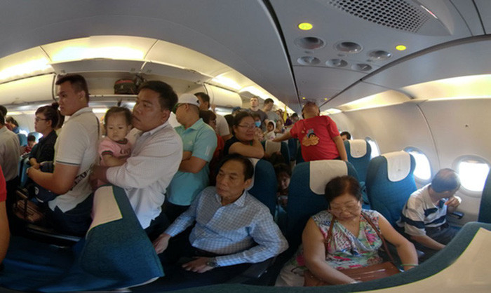 Hành khách chuẩn bị rời máy bay Vietnam Airlines sau khi máy bay hạ cánh vào đường băng chưa khai thác. Ảnh: P.C.B.