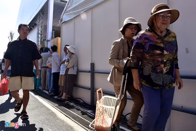 Nhiều khách hàng lớn tuổi phải đi tìm chỗ tránh nắng do chờ quá lâu mới có thể vào trong.