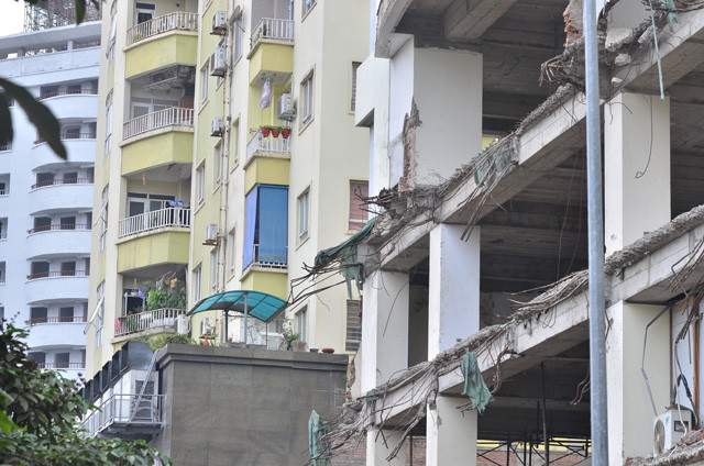 Mặt tiền của tòa nhà như bị đập phá nham nhở trơ ra những thanh sắt hoen gỉ. Mặt tiền của tòa nhà như bị đập phá nham nhở trơ ra những thanh sắt hoen gỉ.