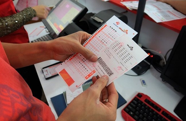 Khách hàng so vé số Vietlott.