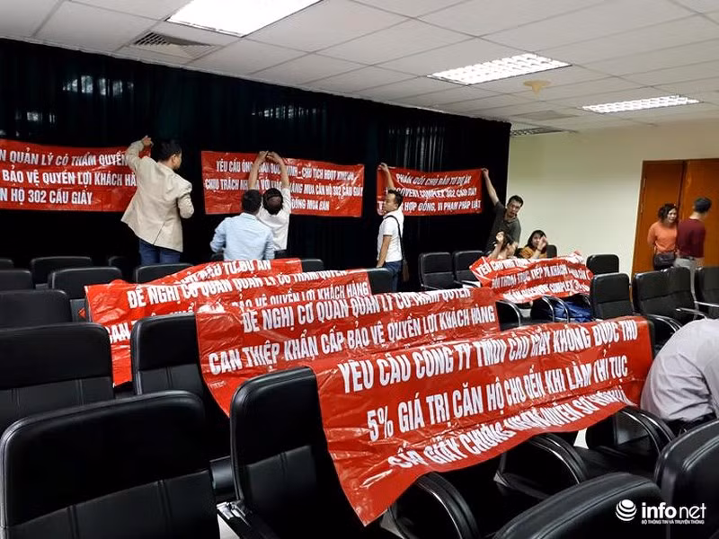 Sau hàng giờ chờ đợi để được gặp lãnh đạo Kinh Đô TCI Group, cư dân làm “nóng” phòng họp của chủ đầu tư bằng những băng rôn màu đỏ... Ảnh: Minh Thư.