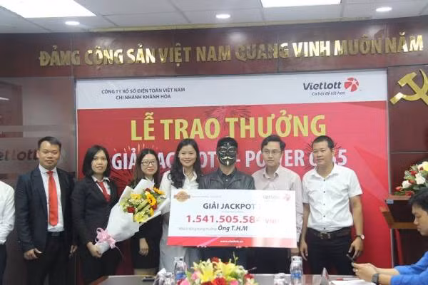 Lãnh đạo Vietlott đang trao giải thưởng cho khách hàng.