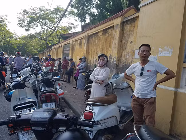 Phụ huynh học sinh đội nắng nóng xếp hàng đợi con tại các điểm thi.