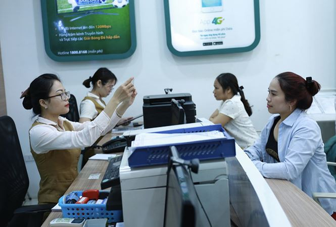 Khách hàng chờ đến lượt cập nhật thông tin người dùng tại một điểm cung cấp dịch vụ viễn thông của Viettel. Ảnh: Như Ý.