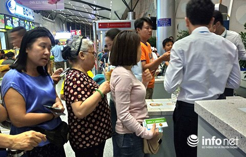 Hành khách xếp hàng chờ phát bánh mì và nước uống.