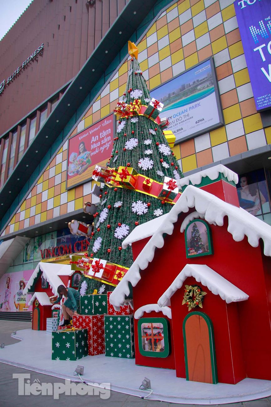 Điểm nhấn trong trang trí với ngôi nhà đỏ, mái phủ tuyết cùng những hộp quà lớn bên cạnh cây thông Noel khổng lồ.