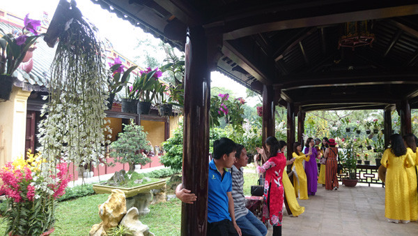 Nhiều phụ nữ diện áo dài chụp ảnh trong không gian hoa lan thanh cao, quý phái. Ảnh: Trần Hòe.