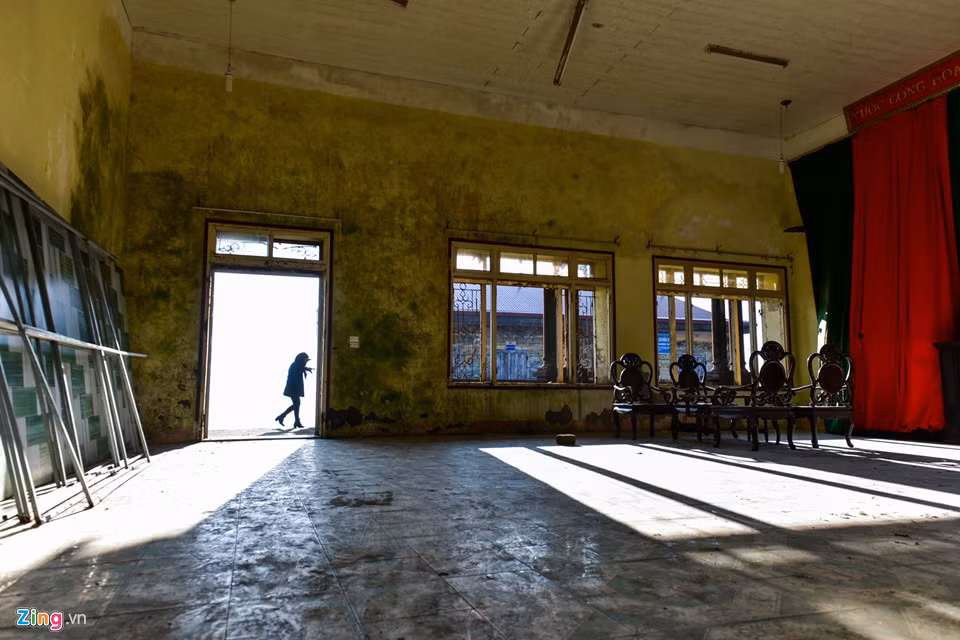 Phòng hội trường vẫn còn khá nguyên vẹn với bộ bàn ghế gỗ bị bỏ hoang và xuống cấp.