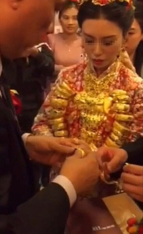 Cô dâu khá vất vả khi đi giữa nhiều vị khách với nhiều trang sức trên người. Trên cổ, các vòng vàng cỡ lớn được xâu thành chuỗi rất đặc biệt.