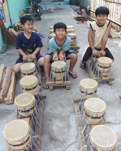 Trẻ con làng trống Bình Lãng vui đùa bên những cái trống cơm.