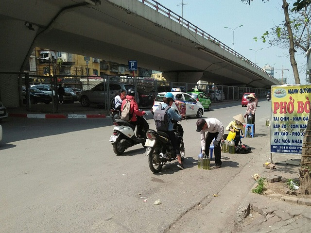 Mua bán xăng ngay lòng đường giữa trưa nắng.