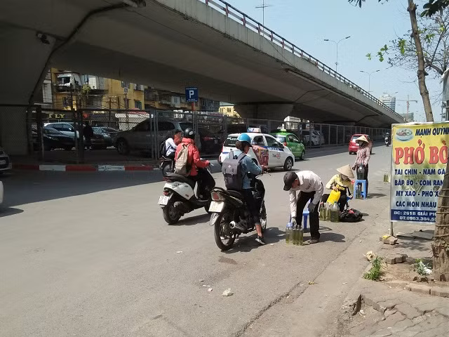 Mua bán xăng ngay lòng đường giữa trưa nắng.