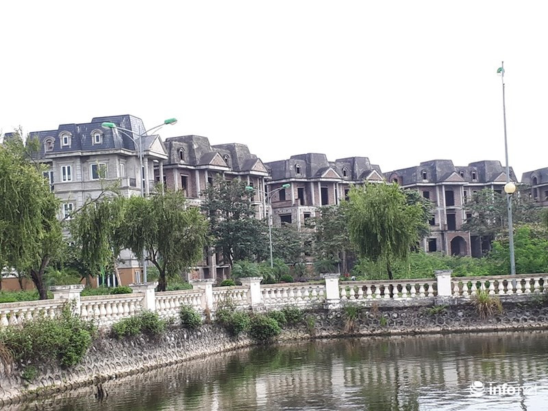 Vẫn còn nhiều dãy nhà mới chỉ xây thô soi bóng bên hồi nước phủ đầy rêu.