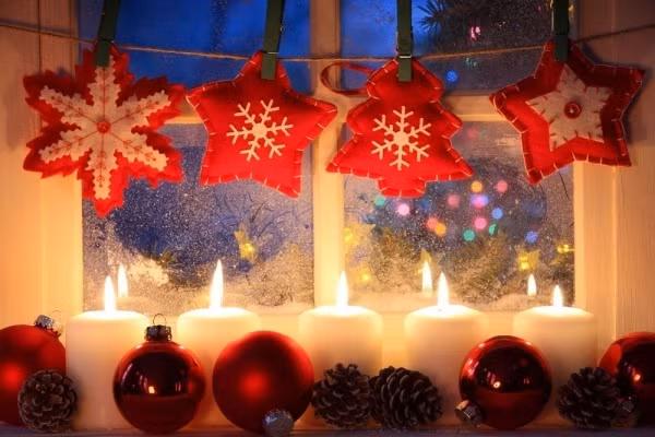 Phía dưới đặt nến màu trắng nổi bật so với tông nền đỏ làm gam màu chủ đạo cũng giúp cho khung cửa sổ đẹp lung linh đầy lãng mạn.