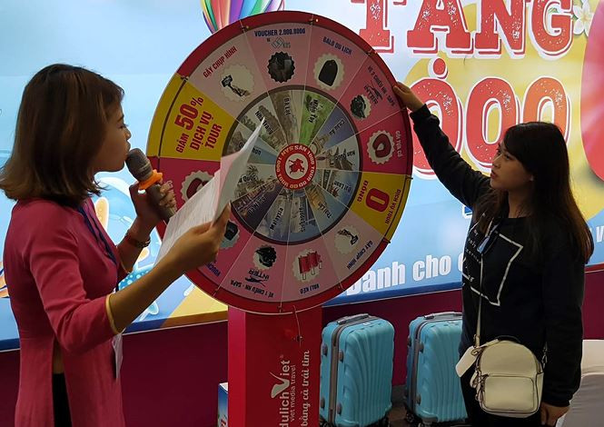 Bạn trẻ tham gia vòng quay may mắn với cơ hội sử dụng Tour du lịch 0 đồng.