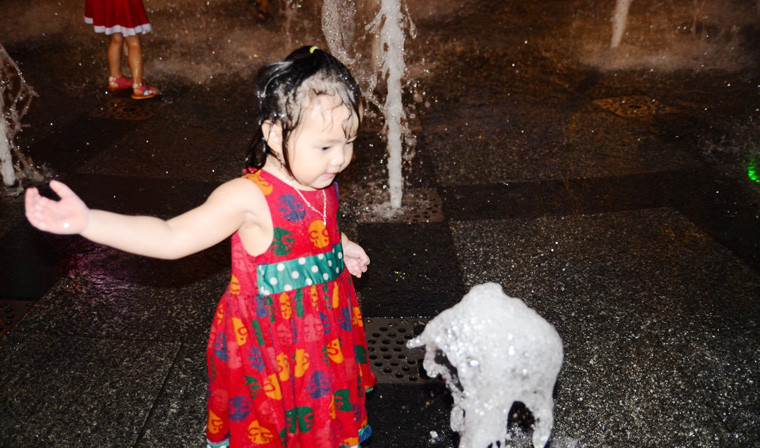 Bé gái cũng nhảy vào tắm giữa thời tiết có phần oi bức ở TP HCM trong đêm Giáng sinh.