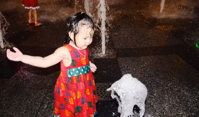 Bé gái cũng nhảy vào tắm giữa thời tiết có phần oi bức ở TP HCM trong đêm Giáng sinh.