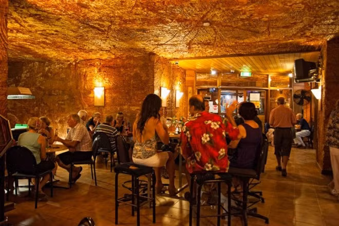 10. Coober Pedy – Australia: Coober Pedy là một thị trấn ở phía bắc Australia, được mệnh danh là “thủ đô Opal của thế giới” do sản lượng lớn đá quý opal của thế giới được khai thác ở đây. Cũng chính bởi người dân ở đây cần khai thác opal nên họ xây dựng những ngôi nhà dưới hầm để tránh khí hậu sa mạc khắc nghiệt và ánh nắng mặt trời. Dần dần, thị trấn ngầm này còn xây dựng hệ thống các khu nhà thờ, nhà hàng, khách sạn dưới lòng đất và có cuộc sống giống hệt như một thị trấn trên mặt đất. Mỗi ngôi nhà đều có một ống khói và trục thông gió nhô lên khỏi mặt đất để lấy oxi. Vào ban đêm, khi nhiệt độ giảm, họ mới lên trên mặt đất và chơi golf cùng nhau với những quả bóng phát sáng ban đêm.
