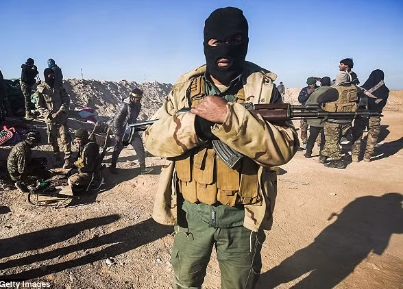 Một chiến binh thuộc lực lượng tình nguyện Iraq Hashed al-Shaabi cầm khẩu súng trường tấn công Kalashnikov trên chiến trường Mosul.