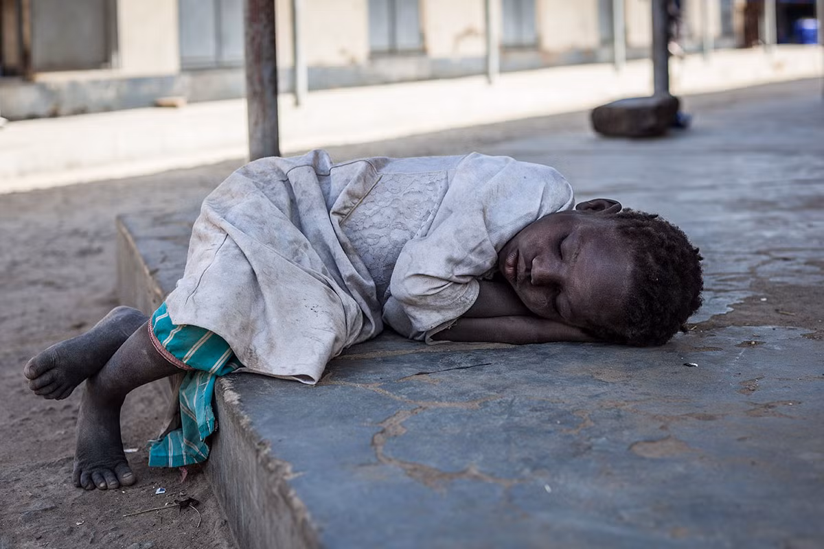 Một em nhỏ ngủ thiếp đi vì mệt sau khi tới một địa điểm ở thị trấn Afoji, Uganda. (Nguồn ảnh: Al Jazeera)