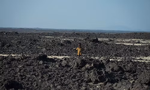 Mặc dù vùng Afar có diện tích gần gấp đôi đất nước Hà Lan, chỉ có hơn 1 triệu cư dân sinh sống trong khu vực này. Ảnh: Một bé trai đứng giữa vùng đất gần núi lửa Erta Ale.