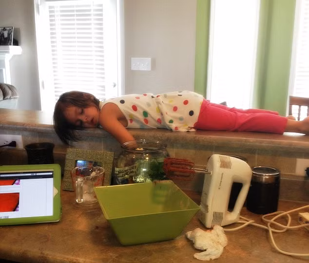 Bé gái ngủ quên trong nhà bếp. (Nguồn ảnh: Daily Mail)