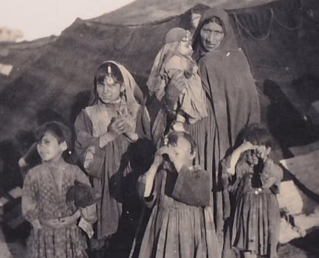 Người phụ nữ và con nhỏ đứng trước lán trại ở North West Frontier năm 1932.