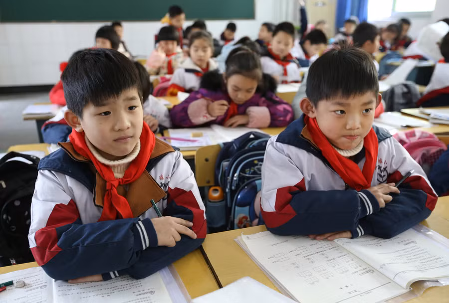 Hai anh em sinh đôi ngồi cạnh nhau trong lớp học.