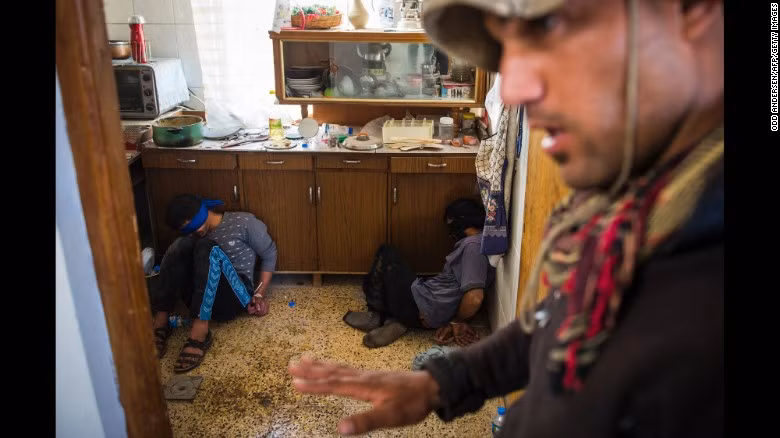 Một đặc nhiệm Iraq đứng canh gác hai chiến binh nghi là thành viên của phiến quân IS ở Mosul ngày 11/11.