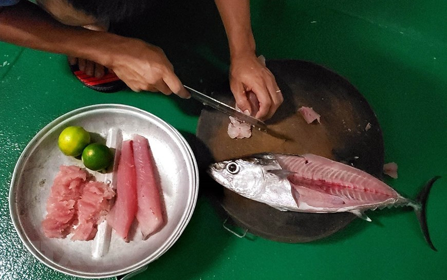 Chế biến món gỏi cá tươi từ cá vừa câu được. (Ảnh: Hoàng Hùng/TTXVN)