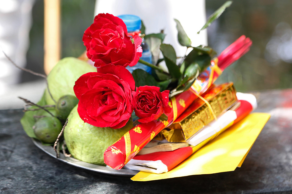 Mâm lễ cầu duyên ngoài hương vàng, giấy áo, miếng trầu, không thể thiếu vài bông hoa hồng - loài hoa tượng trưng cho tình yêu đối lứa - với tờ sớ cầu duyên.